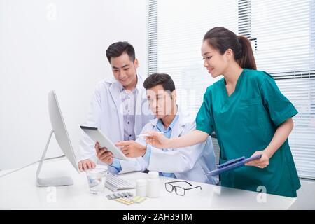 Groupe de médecins et d'infirmières l'examen rapport médical du patient. Équipe de médecins qui travaillent ensemble sur les patients à l'hôpital de fichier. Banque D'Images