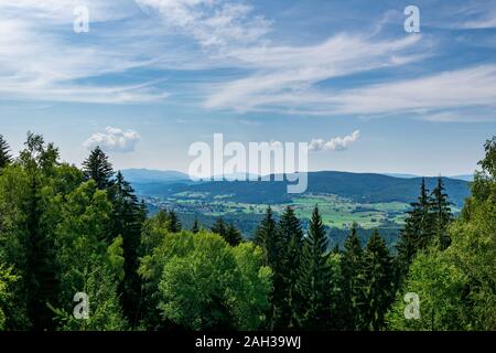 Vue du haut d'une montagne dans la vallée de nuages sur le ciel et les montagnes de l'arrière-plan et les pierres et les arbres en face de l'avant en Bavière Banque D'Images