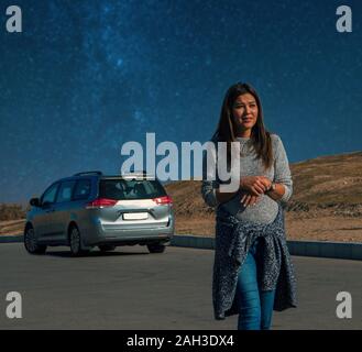 Une jeune femme perdue dans un désert. Des problèmes techniques avec une voiture cassée dans la nuit dans le désert de Karakoum au Turkménistan. Banque D'Images