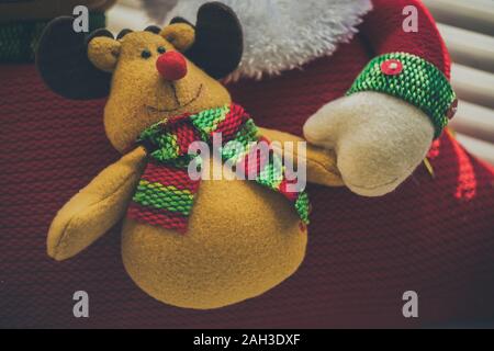 Peluche cerf fête avec sourire heureux et Santa main. Banque D'Images