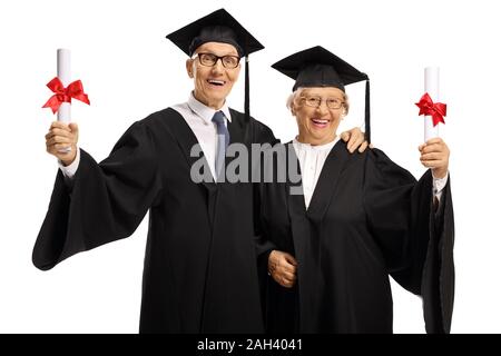 Fier et happy senior man and woman in graduation robes holding diplomas isolé sur fond blanc Banque D'Images