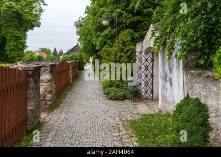 Rue pavées, le long de vieux murs avec portes, Szydlow, Pologne. Banque D'Images