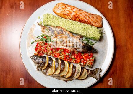 La friture de poissons frais avec une salade de légumes sur une assiette blanche. Banque D'Images