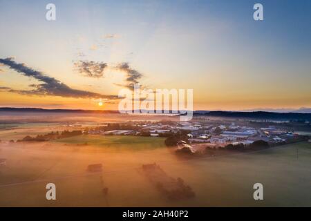 Allemagne, Bavière, Geretsried, vue aérienne de la campagne ville au lever du soleil brumeux Banque D'Images