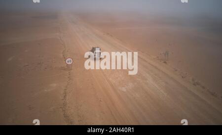 Drone vue d'un 4x4 dans le désert brumeux, Namibie Banque D'Images