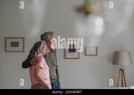 Couple debout dans la salle de séjour à la maison Banque D'Images