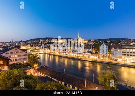 La Suisse, Canton de Zurich, Zurich, Limmat et de la vieille ville de bâtiments le long de la rue au crépuscule lumineux. Banque D'Images