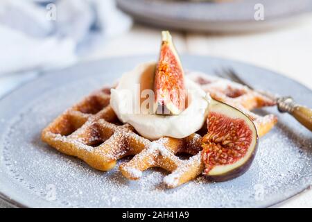 Gaufre Belge épaisse de crème fouettée, le sucre en poudre et des figues Banque D'Images