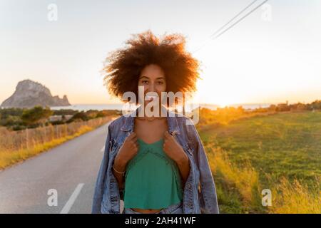 Young woman standing on street au coucher du soleil, Ibiza Banque D'Images