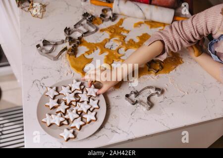 Close-up of girl en tenant la plaque de biscuit de Noël sur kitchencounter Banque D'Images