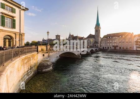 La Suisse, Canton de Zurich, Zurich, Munsterbrucke bridge au coucher du soleil avec en arrière-plan l'église Fraumunster Banque D'Images