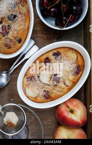 Bols de maison sans gluten clafoutis aux cerises, pêches et amandes Banque D'Images