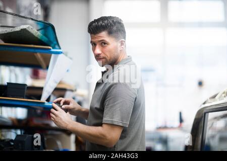 Jeune homme travaillant dans un atelier de rembourrage Banque D'Images