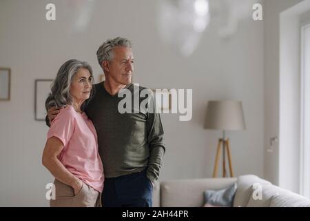 Couple debout dans la salle de séjour à la maison Banque D'Images