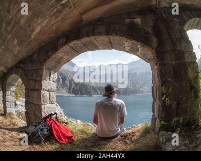 L'Italie, randonneur assis sous le pont, à la recherche de Lago di Salarno Banque D'Images