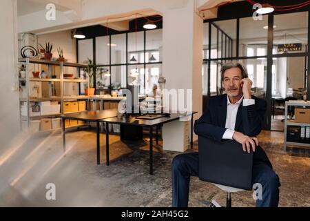 Senior businessman sitting on chair in office Banque D'Images