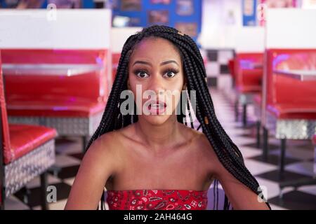 Portrait of a young woman with braided hairstyle dans un restaurant américain restaurant Banque D'Images