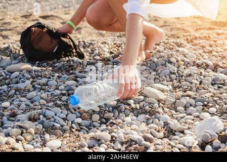 La collecte des bouteilles en plastique femme sur la plage. Concept de la pollution de la terre. Copier l'espace. Banque D'Images