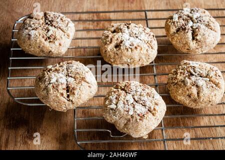 Petits pains de seigle fraîchement cuits au four avec du muesli sur grille de refroidissement Banque D'Images