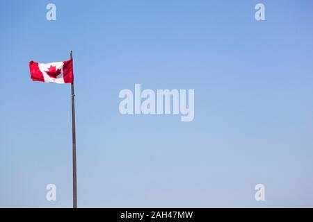 Drapeau canadien contre le ciel bleu Banque D'Images