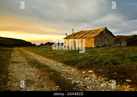 L'Italie, Vérone, Lessinia, Vieille maison en pierre dans domaine au coucher du soleil Banque D'Images