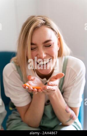 Happy young woman holding un morceau de carotte Banque D'Images