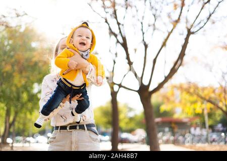 Happy mother with baby boy playing in a park Banque D'Images