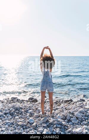 Young woman on beach, stretching her arms Banque D'Images