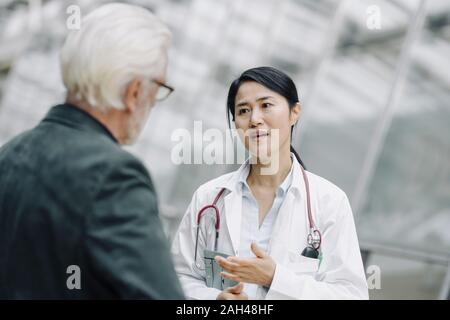 Female doctor talking to senior man Banque D'Images