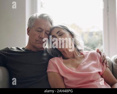 Senior couple sieste sur canapé à la maison Banque D'Images