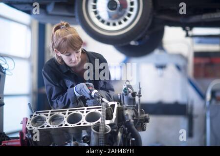 Femme mécanicien automobile voiture garage de réparation de fixation Banque D'Images