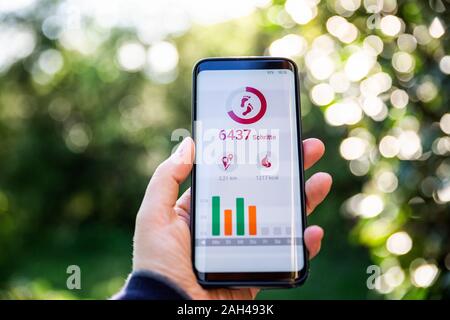 Woman holding smartphone, à l'aide d'app de remise en forme Banque D'Images