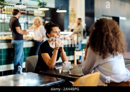 Deux copines se rencontrer et de parler dans un bistro Banque D'Images