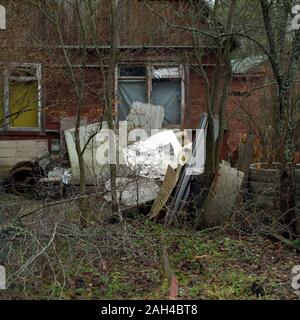 Les déchets abandonnés en face de la vieille maison de bois Banque D'Images