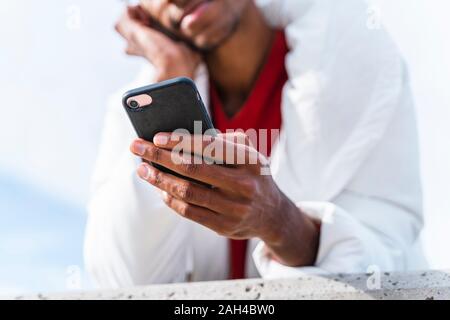 Close-up of young man using smartphone outdoors Banque D'Images