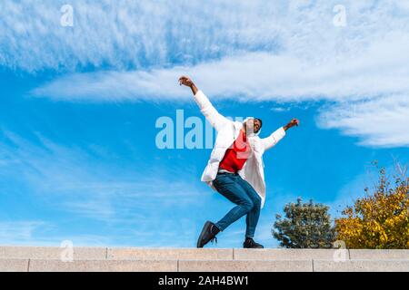 Jeune homme avec un casque déménagement et la danse en plein air Banque D'Images