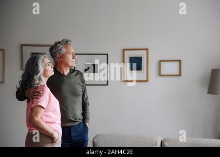 Couple debout dans la salle de séjour à la maison Banque D'Images