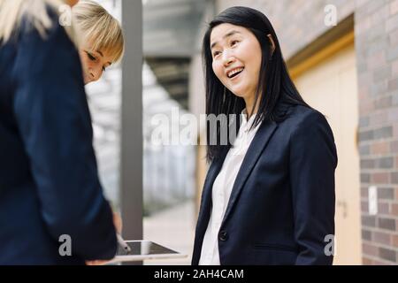 Portrait of happy businesswoman avec des collègues d'immeuble de bureaux modernes Banque D'Images
