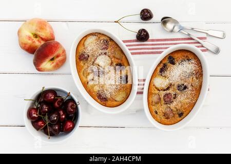 Bols de maison sans gluten clafoutis aux cerises, pêches et amandes Banque D'Images