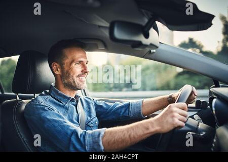 Handsome man driving a car Banque D'Images