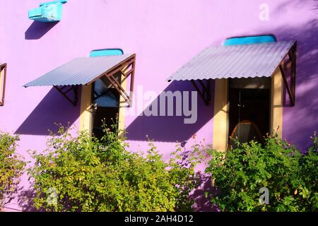 Murs peints en mauve avec des auvents métalliques ondulées avec des touches de bleu turquoise de James Culver boutiques cuir dans Tubac, AZ Banque D'Images