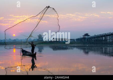 Réglage de pêcheur son filet au sunrise près du pont U Bein, à Mandalay, Myanmar Banque D'Images