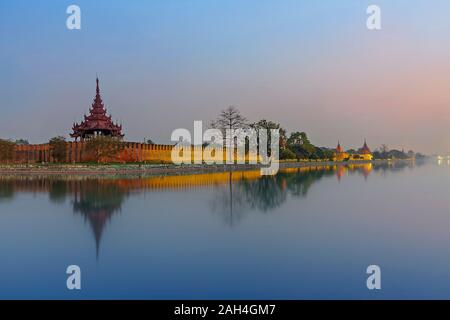 Palais de Mandalay au crépuscule, avec son reflet dans l'eau, Mandalay, Myanmar Banque D'Images