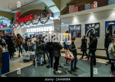 La foule des acheteurs de dernière minute on-line à la Chick-fil-a dans l'aire de restauration du Queens Center Mall dans le borough du Queens à New York, le soi-disant super samedi. le samedi avant Noël, le 21 décembre 2019. Les analystes prédisent détail Super Samedi, qui s'appelle également la panique Samedi, les ventes de surpasser le vendredi noir avec plus de 147,8 millions de personnes shopping. (© Richard B. Levine) Banque D'Images