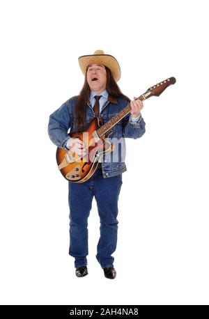 Un bel homme autochtone dans une veste, pantalon jeans et un chapeau de cowboy et permanent à jouer de la guitare, isolée pour fond blanc Banque D'Images