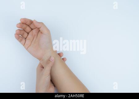 Libre femme détient son poignet douleur sur fond blanc. Concept de santé et de soins médicaux. Banque D'Images