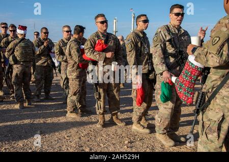 L'Est de la Syrie, la Syrie. 23 Décembre, 2019. Les soldats de l'Armée américaine à attendre en ligne pour recevoir des boissons et des collations après un bas rempli de cadeaux pendant les fêtes de Noël 23 décembre 2019 dans l'est de la Syrie. Le service militaires sont déployés à l'appui de l'opération de lutte contre la volonté inhérente de l'État islamique. Credit : SPC. Ruszkiewicz/Planetpix ange/Alamy Live News Banque D'Images