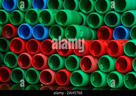 Les barils de plastique utilisé. Bleu, vert et rouge tambour en plastique. Empilés de réservoir vide à food factory en attente de recyclage et de réutilisation. Contenant de matières Banque D'Images