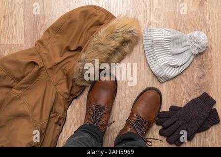 Vêtements chauds pour l'hiver, mens boot, manteau et gants sur plancher en bois Banque D'Images