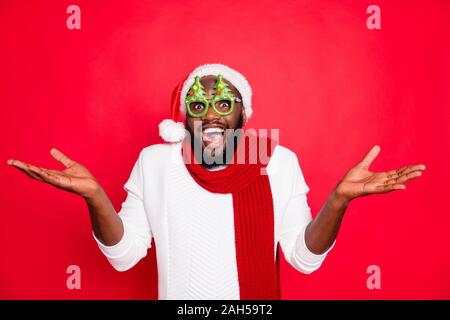 Photo de l'homme drôle peau sombre dans une célébration de l'usure de l'humeur x-mas, evergreen tree specs santa blanc écharpe et chapeau chandail tricoté rouge isolé backg Banque D'Images